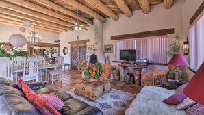 Ein gemütliches Wohnzimmer mit Holzboden, Kamin, Fernseher und Essbereich mit weißer Möbel.