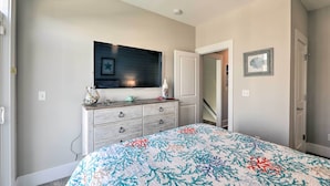 A bedroom with a bed, dresser, and a wall-mounted TV. - Charming Surf City Home w/ Elevator: Walk to Beach (Holly Ridge)