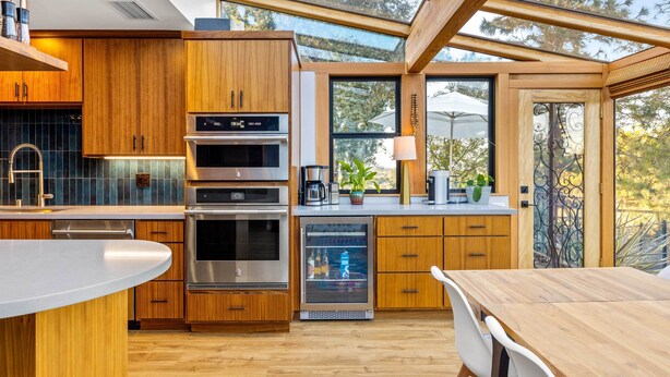A modern kitchen with wooden cabinets, stainless steel appliances, and a glass door refrigerator.