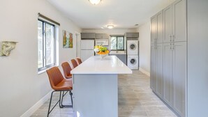 Una cocina moderna con una isla central, armarios grises y un horno empotrado.