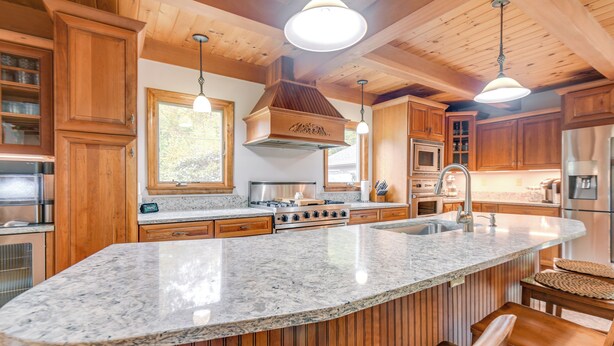 A kitchen with wooden cabinets, a granite countertop, a stove, and a sink. - Milton Hidden Gem w/ Pool, Hot Tub & Fireplace! (Milton)