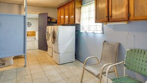 Une buanderie équipée d’un lave-linge, d’un sèche-linge et d’armoires en bois.