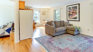 A living room with a grey sofa, a patterned rug, and a painting on the wall. - Charming Chester Apartment: Steps to Main Street! (Chester)