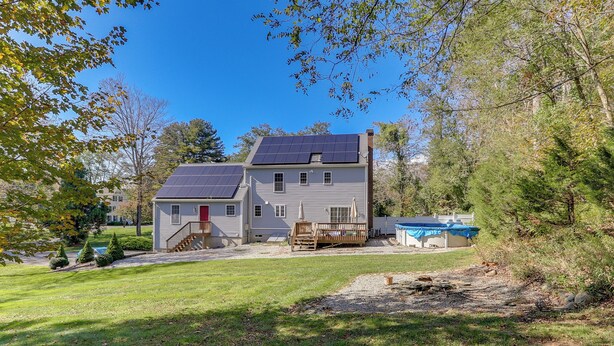 A two-story house with solar panels, a red door, and a deck. - Charming Chester Apartment: Steps to Main Street! (Chester)