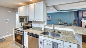 A modern kitchen with white cabinets, stainless steel appliances, and a granite countertop. - Waterfront Gilbertsville Retreat on Kentucky Lake! (Gilbertsville)