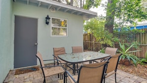 A patio with a table and chairs, a door, and a window. - Pet-friendly Gulfport Home: Walkable Location! (St. Petersburg)