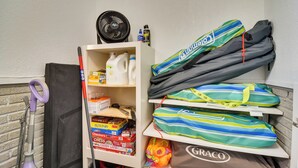 A storage area with cleaning supplies, a vacuum cleaner, and several colorful bags. - Pet-friendly Gulfport Home: Walkable Location! (St. Petersburg)