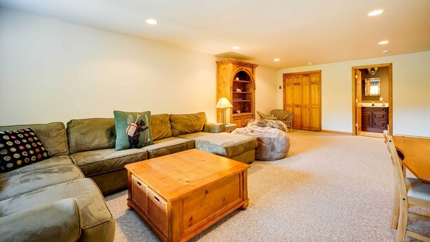A living room with a sectional sofa, a wooden coffee table, and a lamp. - Winhall Home w/ Deck + Views, 6 Mi to Ski Slopes! (Bondville)