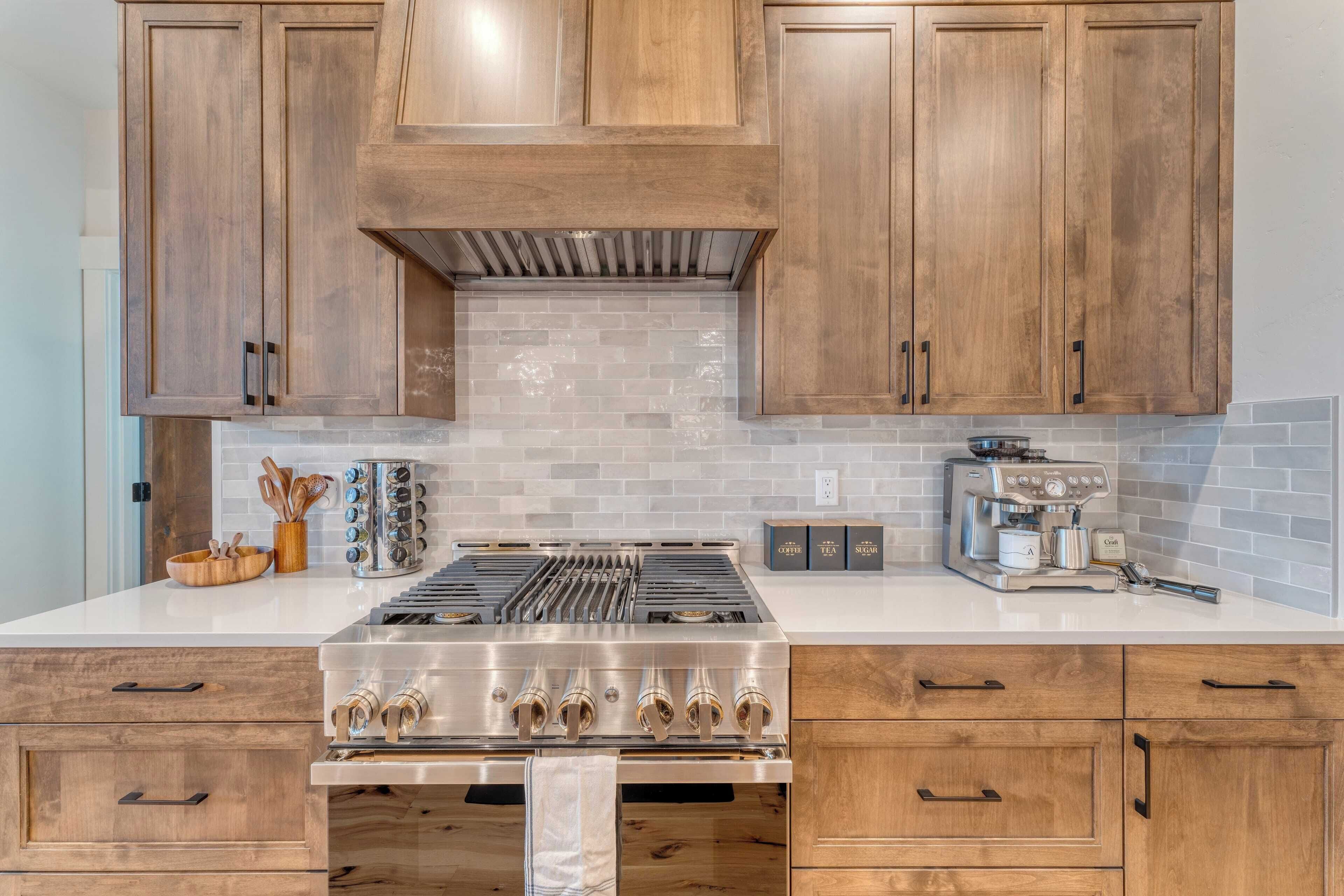 A kitchen with wooden cabinets, a stainless steel stove, and a coffee maker.