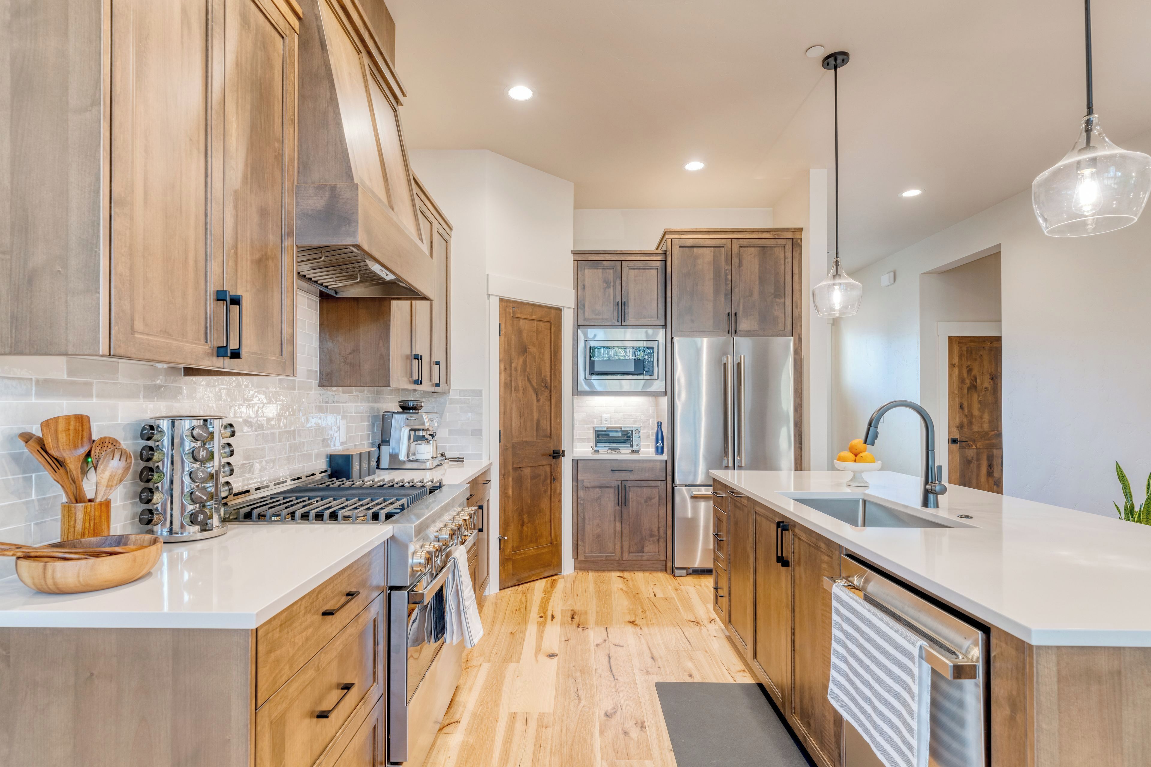 Une cuisine moderne avec des meubles en bois, des appareils électroménagers en acier inoxydable et un îlot central.