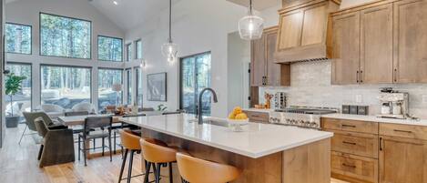 Une cuisine moderne dotée d’un grand îlot central, de meubles en bois et de grandes fenêtres.