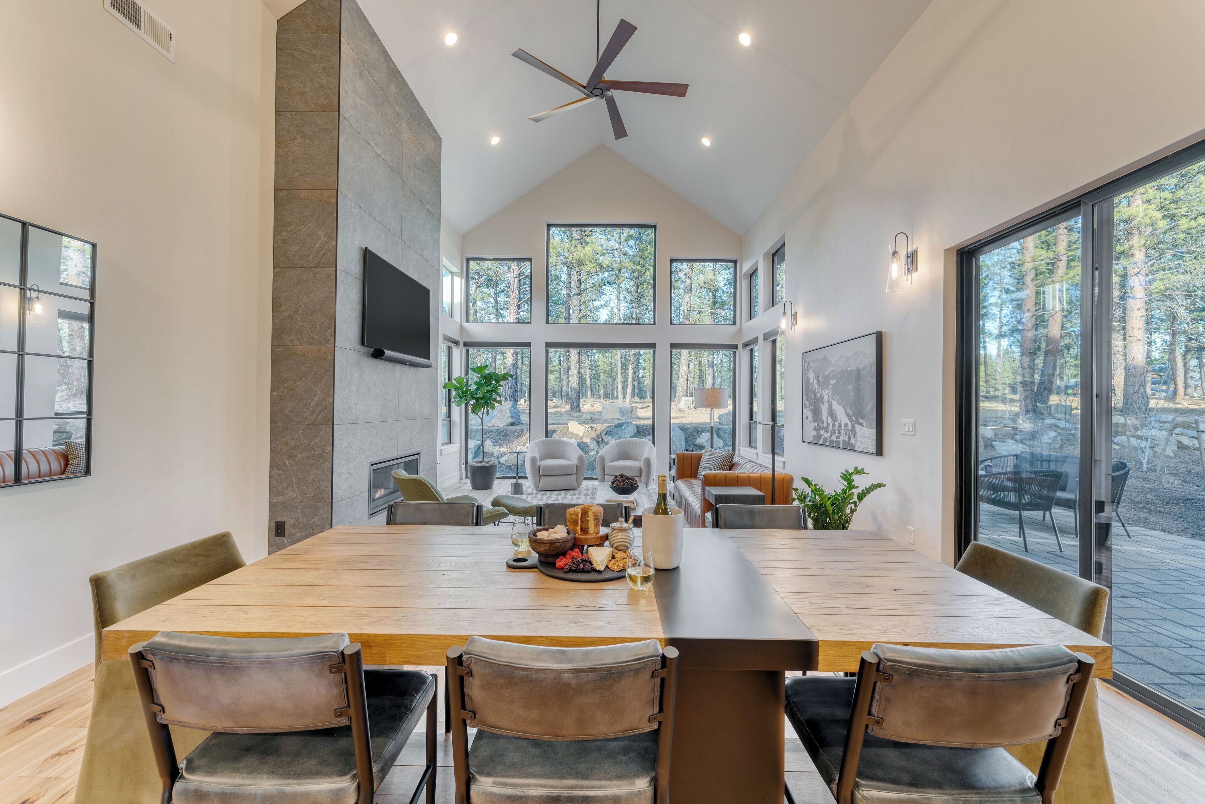 A spacious dining area with a long wooden table, multiple chairs, and a ceiling fan.