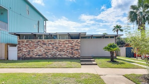 Uma casa moderna com parede de tijolos e fachada azul.