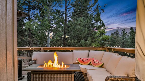 An outdoor deck with a fire pit, wicker furniture, and a view of trees and hills. - 4bdmountain Getawaydog Friendlyminutes to Pikes Peak & Nature (Woodland Park)