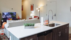 Une cuisine moderne dotée d’un grand îlot central, d’un lave-vaisselle encastré et d’un évier.