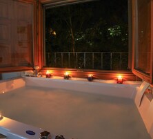 Una bañera grande con velas en una habitación con poca luz.