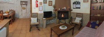 Una sala de estar acogedora con chimenea, muebles de madera y televisor.