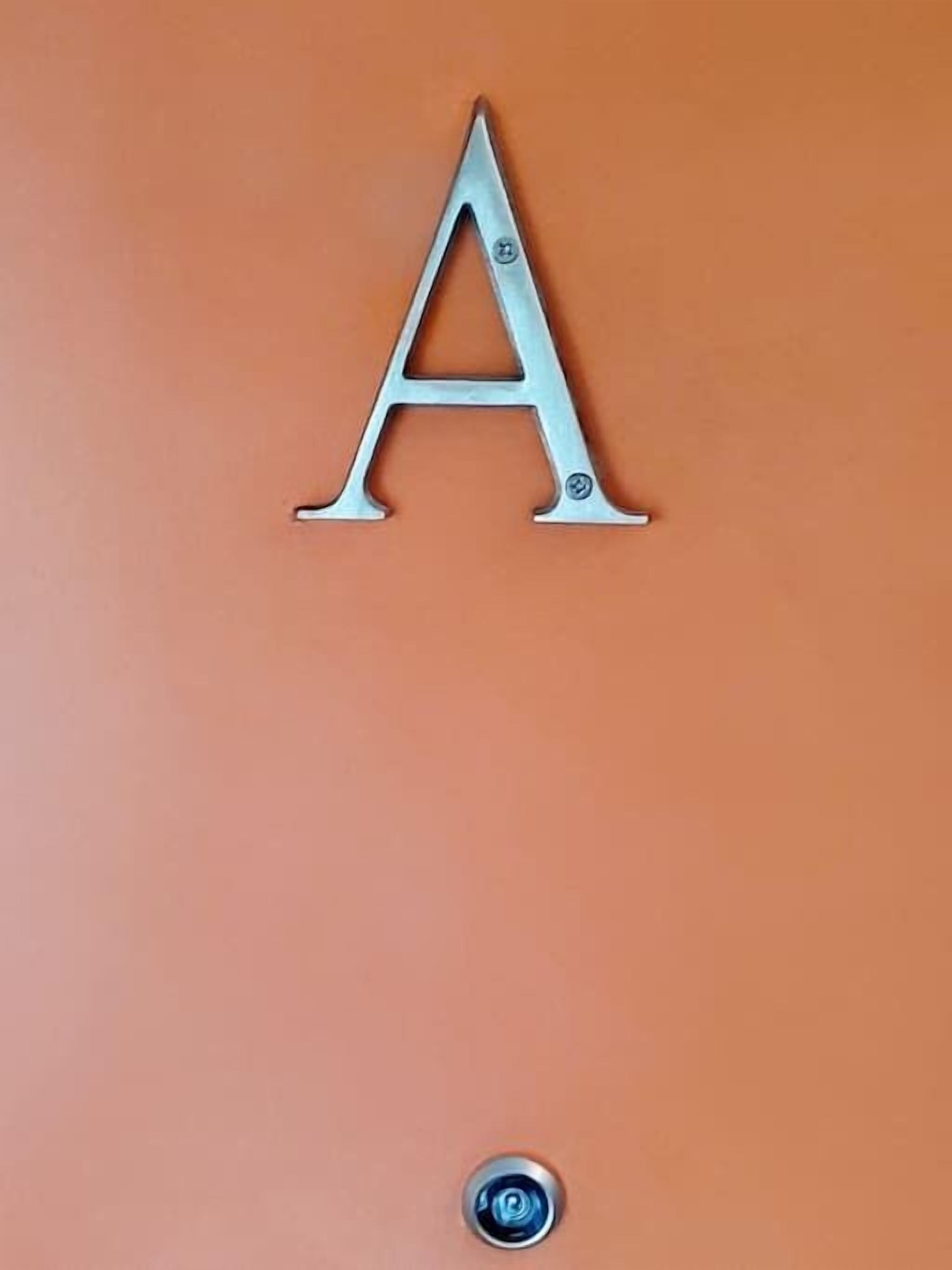 Una letra 'A' de metal fijada a la pared.