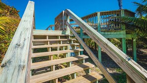 A wooden staircase leading to a wooden platform with a statue on top. - Tranquility Octopus Suite - Oceanfront Paradise! (Melbourne Beach)