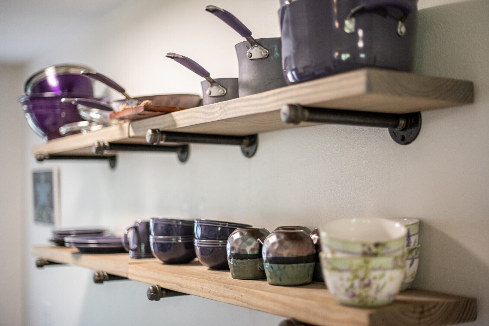 A kitchen shelf with various kitchenware items.