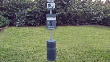 A dog waste station with a sign instructing to clean up after your dog.