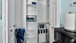 A walk-in closet with open doors, shelves, and a hanging rack. - Crane Creek Inn Manatee Suite: Waterfront Pool! (Melbourne)