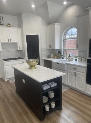 Frigorífico, placa de cocina, utensilios de cocina y mesa de comedor