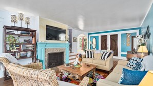 A living room with a fireplace, a sofa, a coffee table, and a bookshelf.