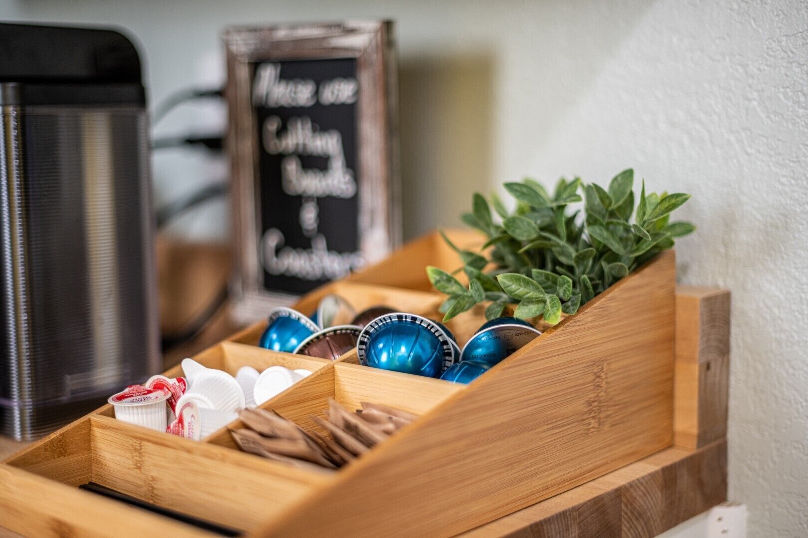 Een houten dienblad met koffiekopjes en een bordje met de tekst 'Alleen koffiekopjes gebruiken'.