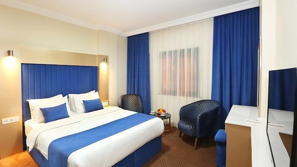 A hotel room with a large bed, a desk, a chair, and a television. - Taksim ABC Hotel (Istanbul)