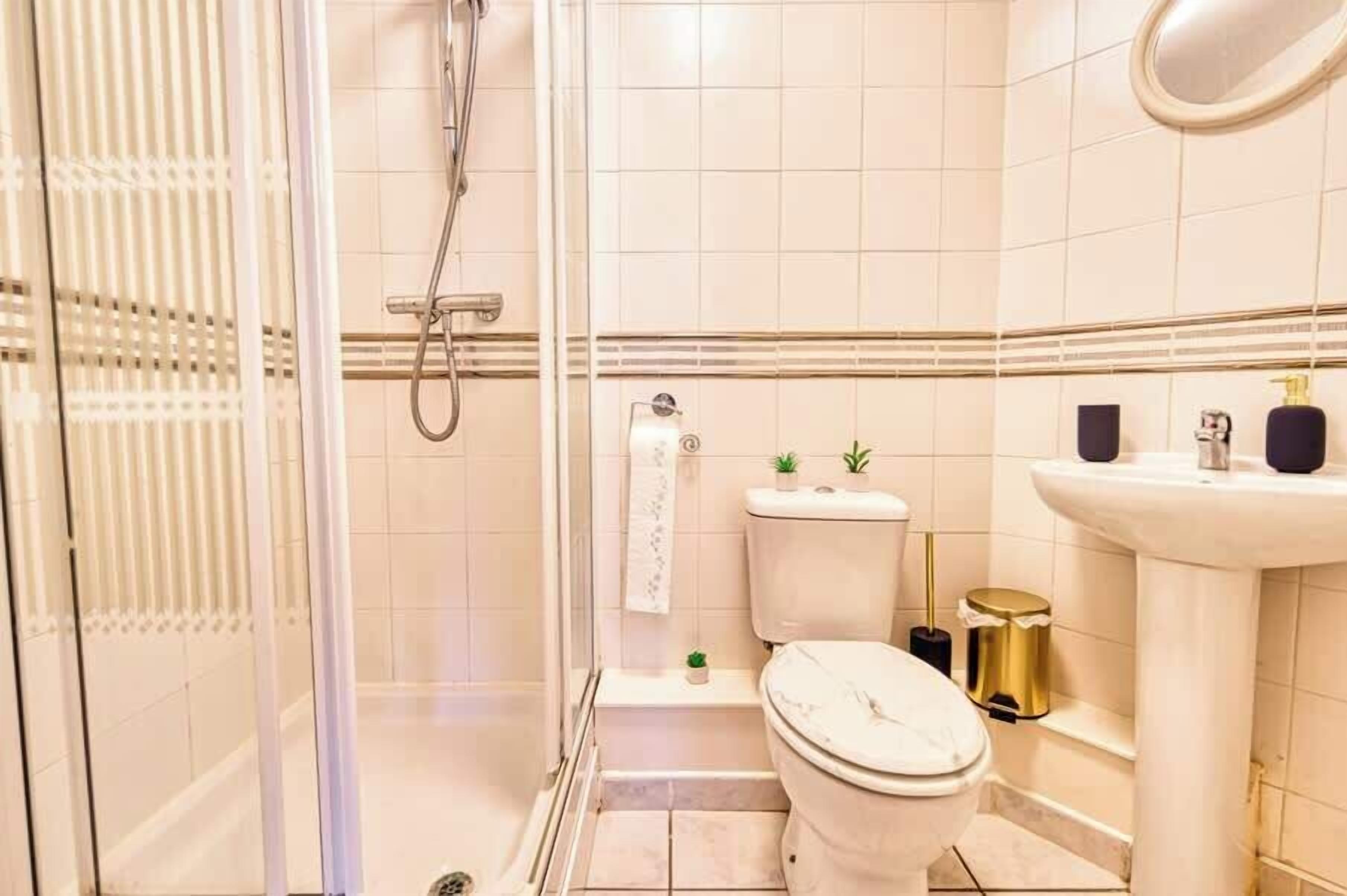 A bathroom with a toilet, sink, and shower.