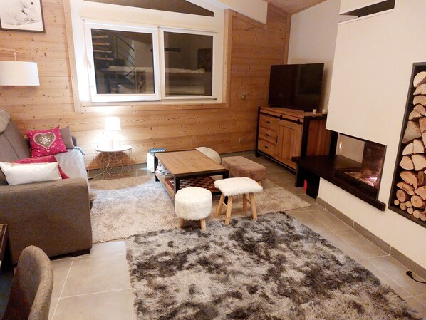 Una sala de estar acogedora con un sofá, una mesa de centro y una chimenea.