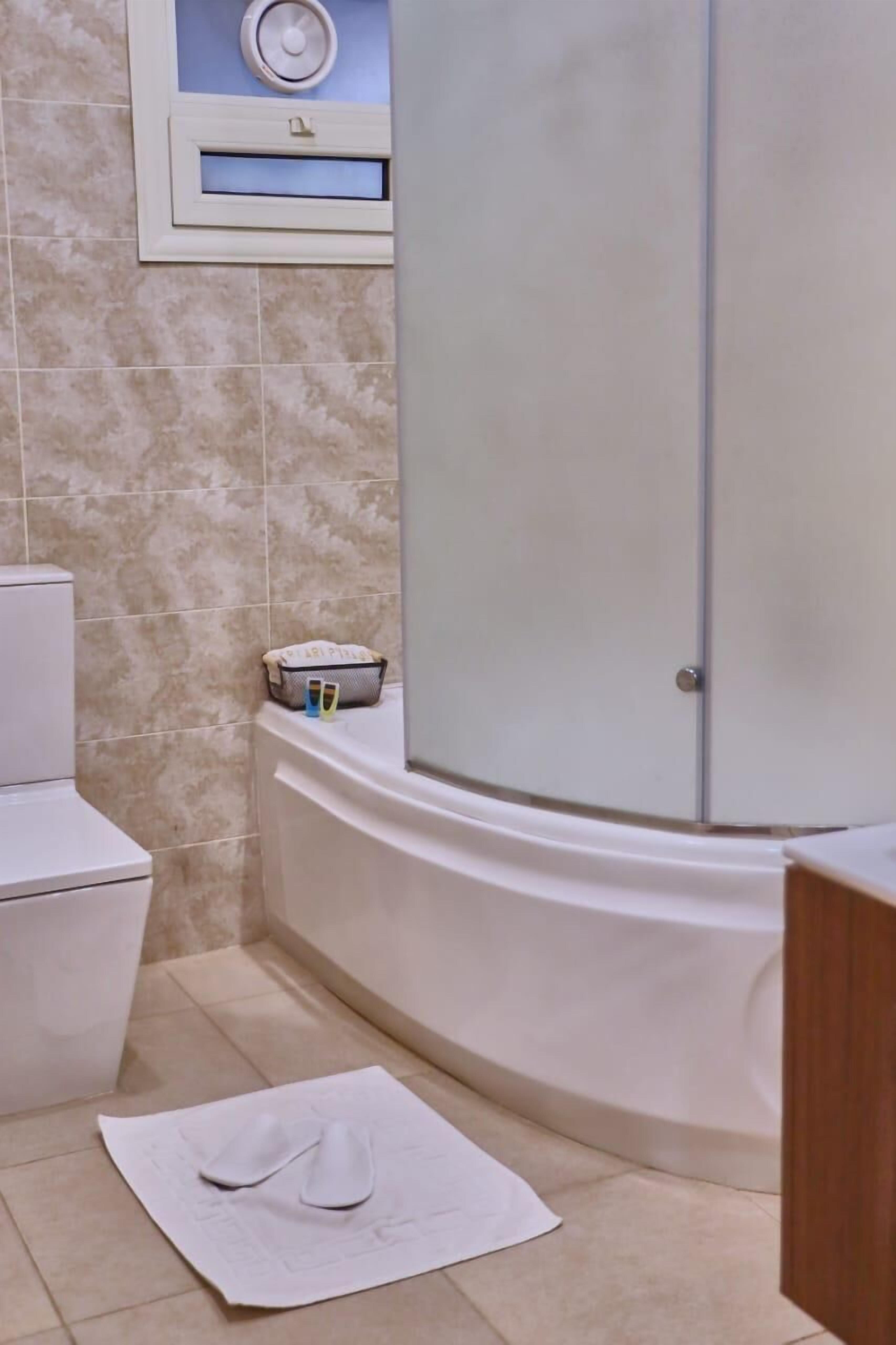 Een badkamer met een toilet, een bad en een wastafel.