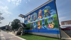 A wall with a colorful mural advertising Cedar Falls.