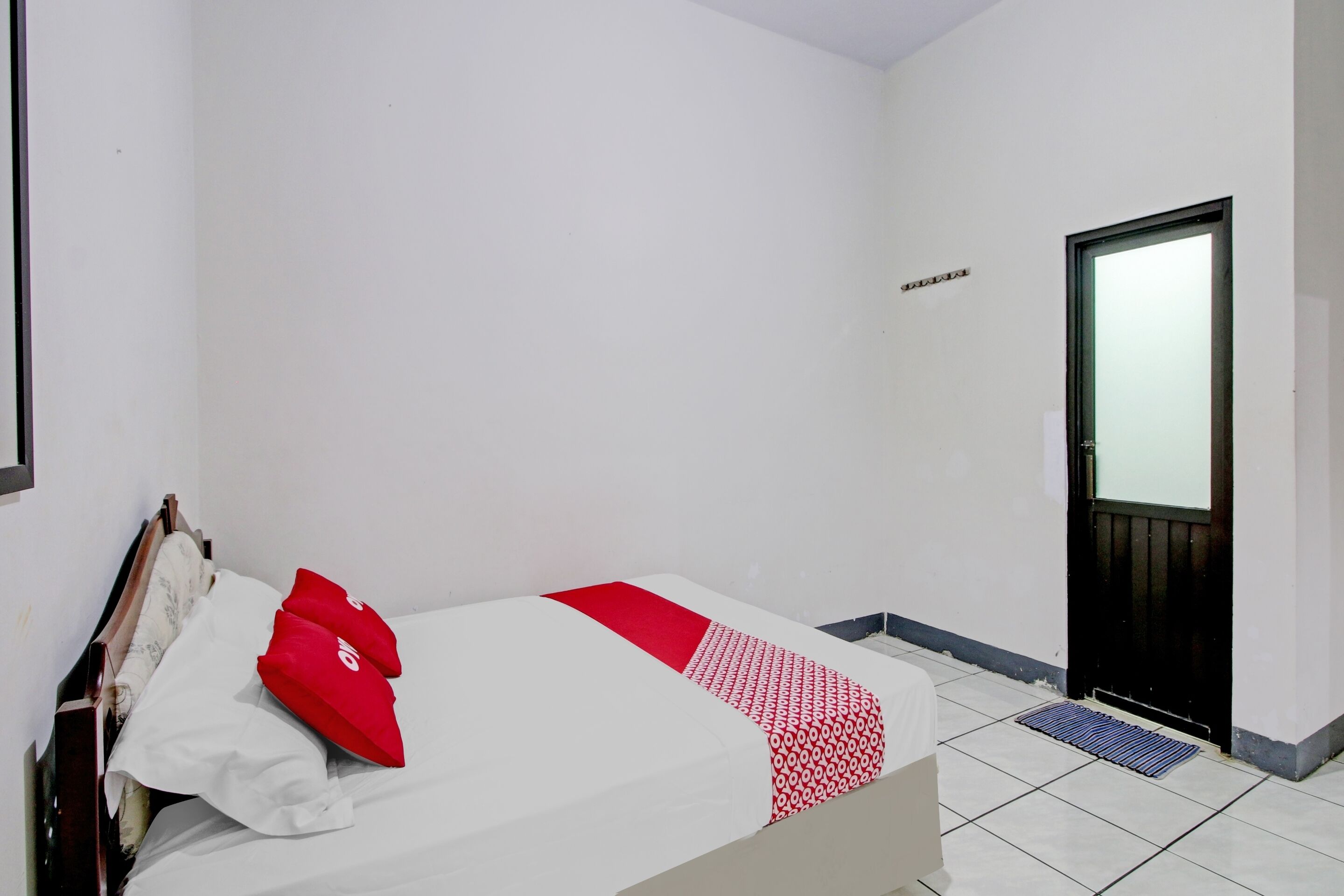 A room with a bed, a door, and a wall-mounted sign.