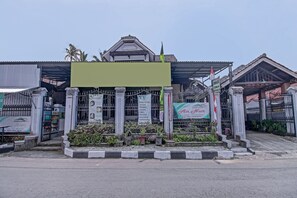 A building with a covered entrance, a signboard, and a flag. - OYO 90543 An-nur Guest House Syariah (Jalaksana)