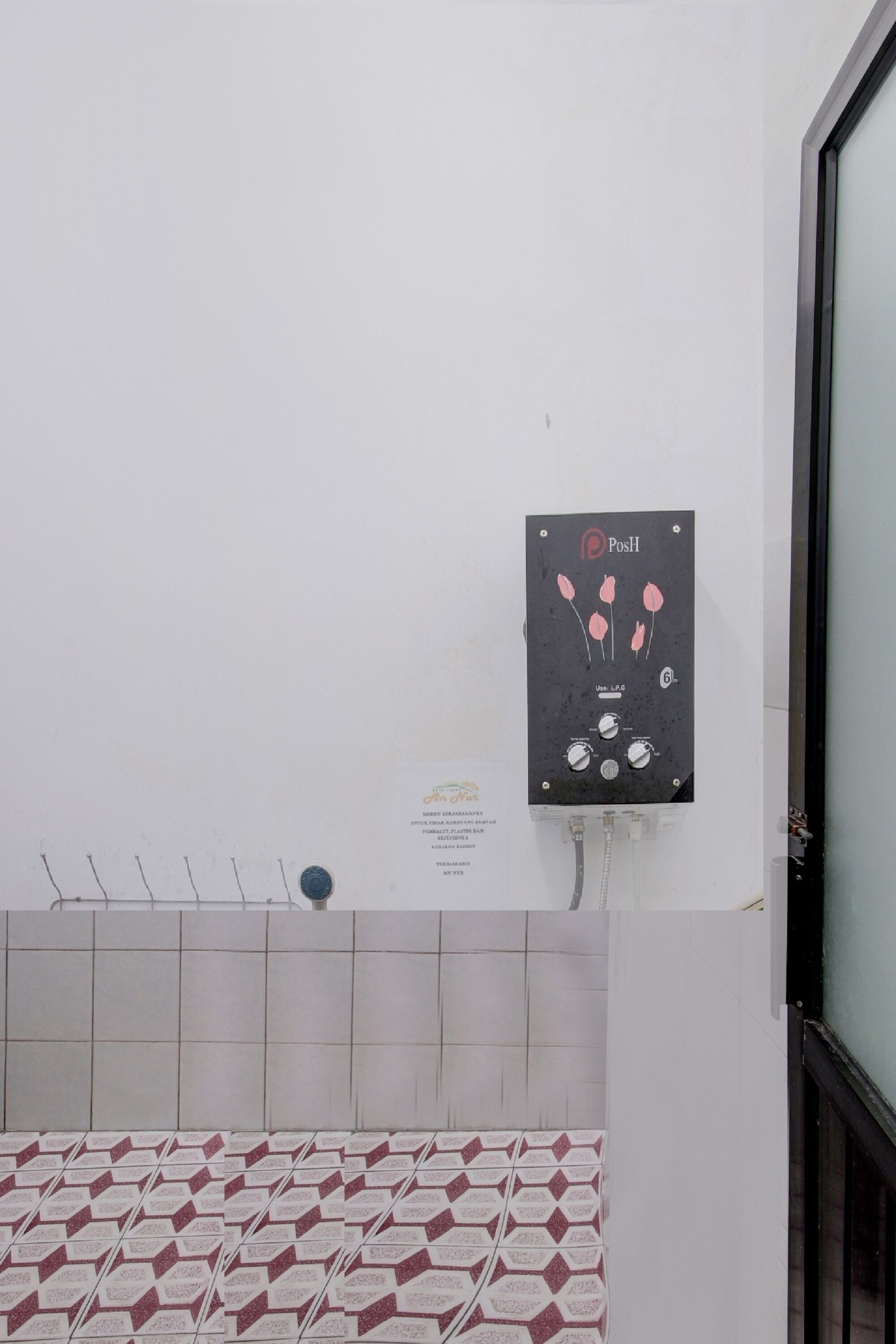 A control panel with a logo, a wall-mounted device, and a tiled floor pattern.