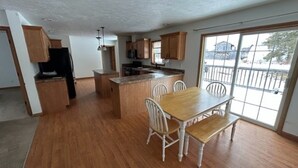 A spacious kitchen with wooden cabinets, a central island, and a dining area with a bench. - NEW LISTING - FARMHOUSE --VERY CLOSE TO SNOWMOBILE TRAILS - VERY PRIVATE (Brimley)