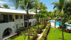 Ein Resort mit Pool, Palmen und einem gepflegten Garten.