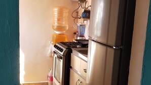 A kitchen with a refrigerator, oven, and a water dispenser.