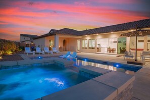 Una casa moderna con piscina, mobiliario de exterior y zona de patio.