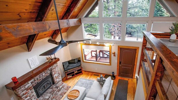 Ein Loft-Wohnzimmer mit Kamin, einer Couch und einem Deckenventilator.