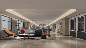 A modern hotel lobby with a sofa, chairs, a coffee table, and vending machines. - Holiday Inn Express Changsha Development Zone by IHG (Changsha)