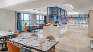 A modern hotel lobby with a dining area, a bar, and a view of the city. - Holiday Inn Express Changsha Development Zone by IHG (Changsha)