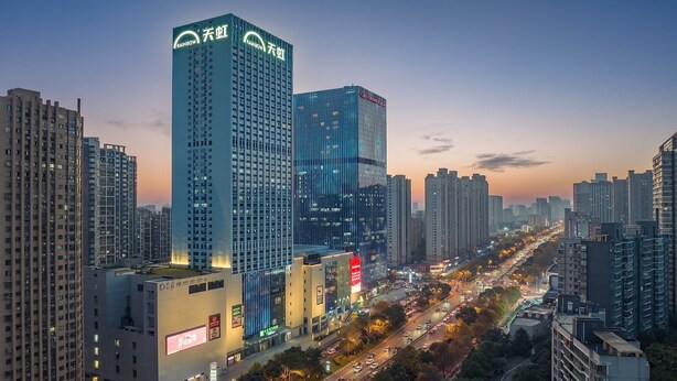 A high-rise building with multiple floors and a prominent "Rainbow" sign on the top. - Holiday Inn Express Changsha Development Zone by IHG (Changsha)