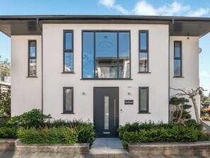 A modern two-story building with a dark front door, multiple windows, and a sign reading 'The Brook.' - Step into indulgence, where every detail is tailored for your comfort. (Cradley, near Malvern)