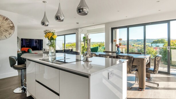 A modern kitchen with a large island, pendant lights, and a view of the outdoors. - Step into indulgence, where every detail is tailored for your comfort. (Cradley, near Malvern)