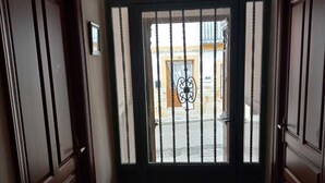 A hallway with a wrought iron gate marked "SALIDA" leading to an outdoor area.