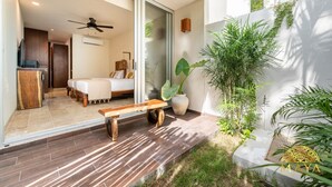 A modern interior with a bed, bench, and potted plants. - NHOA 108C Lux 1BR Condo Plunge Pool in Aldea Zama (Tulum)