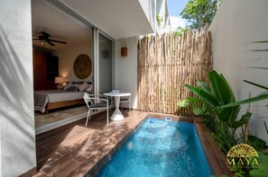 An outdoor pool area with a bamboo fence, a small table, and chairs. - NHOA 112A Lux 2BR Condo Plunge Pool in Aldea Zama (Tulum)